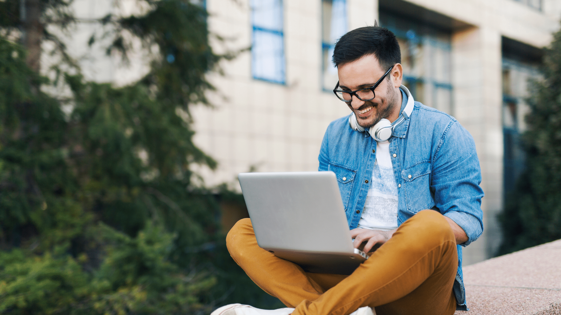 An image of a freelancer working outside of the office on thier laptop.